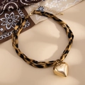 Detail eines Choker-Halsbandes mit Leopardenmuster und glänzendem goldener Herzanhänger - Goldenes Herzmodell (07104)