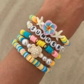 Nahaufnahme bunter Sommerarmbänder mit Frangipani, Schildkröten und Seesternperlen - Bunte Vitalität SUMMER Stil