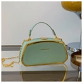Dettaglio borsa a scatola verde menta con bordo in metallo dorato e tracolla a catena - verde chiaro