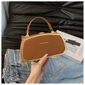 Detail of a brown leather box bag with gold metal frame and fashion chain strap - Tan