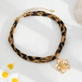 Detail der Leopard-Stoff-Halskette mit glänzendem goldener Blumen-Anhänger - Goldenes Blumenmodell (07103)