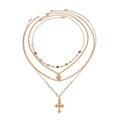 Four-layer gold necklace set featuring cross pendant, pearl chain, and sun charm detail - Gold-06157
