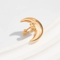 Close-up of golden crescent moon body piercing with detailed face and polished finish - Gold Moon Face Style (03555)