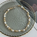 Detalle de collar con perlas barrocas y estrellas doradas en bandeja vintage - Dorado