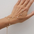 Detail of gold finger bracelet featuring delicate white pearls and crystal chain on hand - Gold Pearl Rhinestone Style (02863)