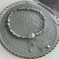 Detalle de collar plateado con perla barroca y colgantes de estrella y cruz - Plateado