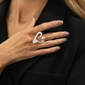Macro detail of a thick polished heart ring worn on finger with a sleek metallic finish - Silver / Abstract Heart Shape (00961)
