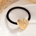 Elastic black hair tie featuring a large hammered gold heart pendant accessory - Hammered Heart Gold (0072)