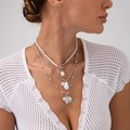 Close-up of layered baroque pearl necklaces with shell and fish pendants on a model - White K (06215)