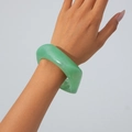 Close-up of translucent light green acrylic bangle with marbled cloud texture on wrist - Green
