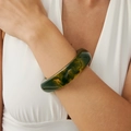 Close-up of retro marble pattern acrylic bangle with dark green and amber resin textures - Ink Wash Green