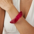 Close-up of a wide translucent deep red resin bangle with a natural fluid texture on a wrist - Red Purple