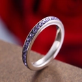 Titanium steel ring featuring a full circle of channel-set purple round gemstones - June Birthstone