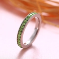 Silver titanium ring featuring a row of micro-set round green zirconia birthstones - August Birthstone