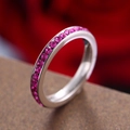 Eternity ring with channel-set magenta birthstones in a silver-tone metal band - October Birthstone