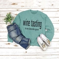 Flat lay of a teal crewneck sweatshirt with black Wine Tasting print on white wood floor - S / Light Green (Black Text)