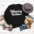 Detailansicht vom schwarzen Whiskey Weather Sweatshirt mit Winter-Accessoires auf Holzboden - S / Schwarzes Sweatshirt (Weiße Schrift)