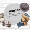 Detailweergave van grijze crewneck sweatshirt met Seester-print op herfst platte lay - S / Wit (Zwart Lettertype)