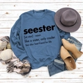Flat lay of navy blue Seester sweatshirt styled with winter accessories on wood - S / Blue (Black Font)