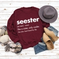 Detail of burgundy crewneck sweatshirt with white Seester letter print in flat lay setup - S / Wine Red (White Font)
