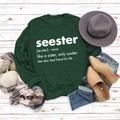 Flat lay of green Seester printed sweatshirt with autumn accessories on white wood - S / Dark Green (White Font)