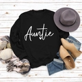 Flat lay of black long sleeve Auntie sweatshirt with autumn accessories on wood background - M / Black Sweatshirt (White Font)