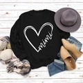 Flachliegendes schwarzes Sweatshirt mit Herz- und Mimi-Print auf Holz hintergrund - S / Schwarz (Weißer Druck)