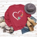 Close-up of red sweatshirt featuring a colorful heart and pet paw print design on wood - S / Red