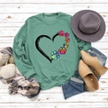 Flat lay of bean green sweatshirt with heart and rainbow dog paw print and autumn accessories - S / Light Green
