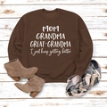 Détail d'un sweat marron avec imprimé Mom Grandma Great-Grandma sur fond en bois - Café (Police Blanche)