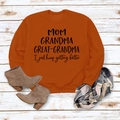 Détail de l'imprimé slogan MOM GRANDMA sur sweat-shirt orange sur fond en bois - Orange Brûlé (Police Noire)