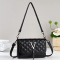 Macro detail of black quilted leather texture with silver V logo and metallic fringe - V-Logo Tassel Style (909-4)