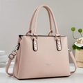 Detail showing litchi grain leather texture and silver hardware on a pale pink tote bag - Pink
