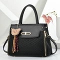 Elegant black faux leather and knit handbag with gold hardware and plush bear charm - Black