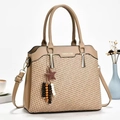 Detail der gewebten Handtasche mit khakifarbenem Lederbesatz und Sternanhänger - Hellbeige