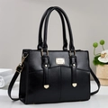 Detail of black faux leather tote with golden hardware, round handles and adjustable strap - Black