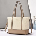 Macro detail of large tote bag showing herringbone straw weave and khaki faux leather textures - Khaki