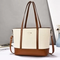 Minimalist beige woven tote bag with brown leather accents and gold metal plaque - Earthy Yellow