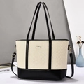 Detail of herringbone weave tote bag with black leather handles and gold metal hardware - Black