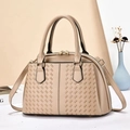 Detailed view of beige woven texture handbag with golden hardware and leather strap - Khaki