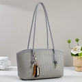 Graue Web-Tote Bag mit Fischgrätenmuster und Perlen-Quaste in minimalistischer Szenerie - Grau