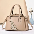 Detail der khakifarbenen Lederhandtasche mit feiner Blumenstickerei und goldener Hardware - Khaki