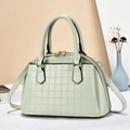 Détail du sac à main vert menthe avec texture carrée gaufrée et fermetures éclair dorées - Vert