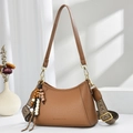 Détail du sac sous l'aisselle en cuir marron foncé avec pendentif perles ethniques - Abricot