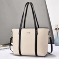 Minimalist beige woven tote bag with black PU leather straps and golden metal tag - Black