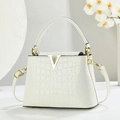 Détail d'un sac à main blanc à texture crocodile avec logo métallique en V doré - Blanc Cassé