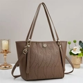 Deep brown embossed tote bag with heart patterns and gold hardware on white desk - Khaki