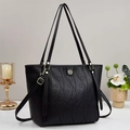 Detail of black pebbled leather tote bag with heart embossed pattern and gold hardware - Black