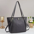 Détails macro du sac cabas gris foncé avec motifs de cœurs embossés et logo en métal - Gris
