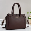 Dark brown pebble leather tote bag with gold hardware and dual handles shown in a home setting - Coffee